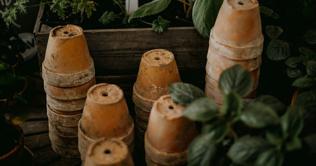 Multiple stacks of terracotta pots, each with a drainage hole.